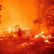 A firefighter works the scene as flames push towards homes during the Creek Fire in 2020.